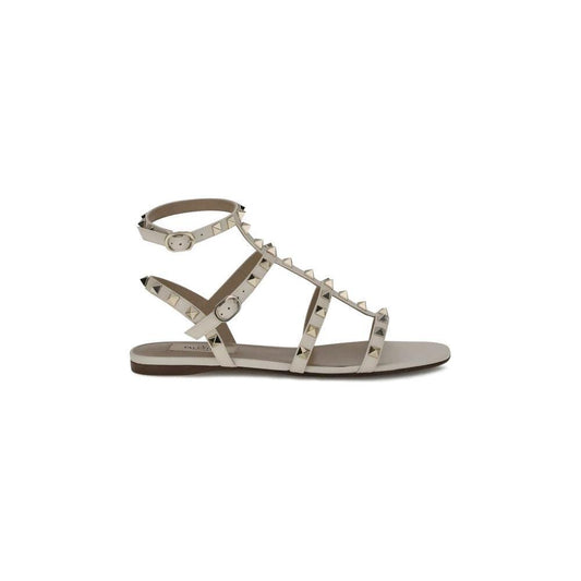Valentino Garavani Rockstud SandalsValentino Garavani’s leather Rockstud Sandals combine bold style with refined comfort. Featuring a round toe and an adjustable ankle lap strap closure with a side buckle, they offer a secure and personalized fit. The fla